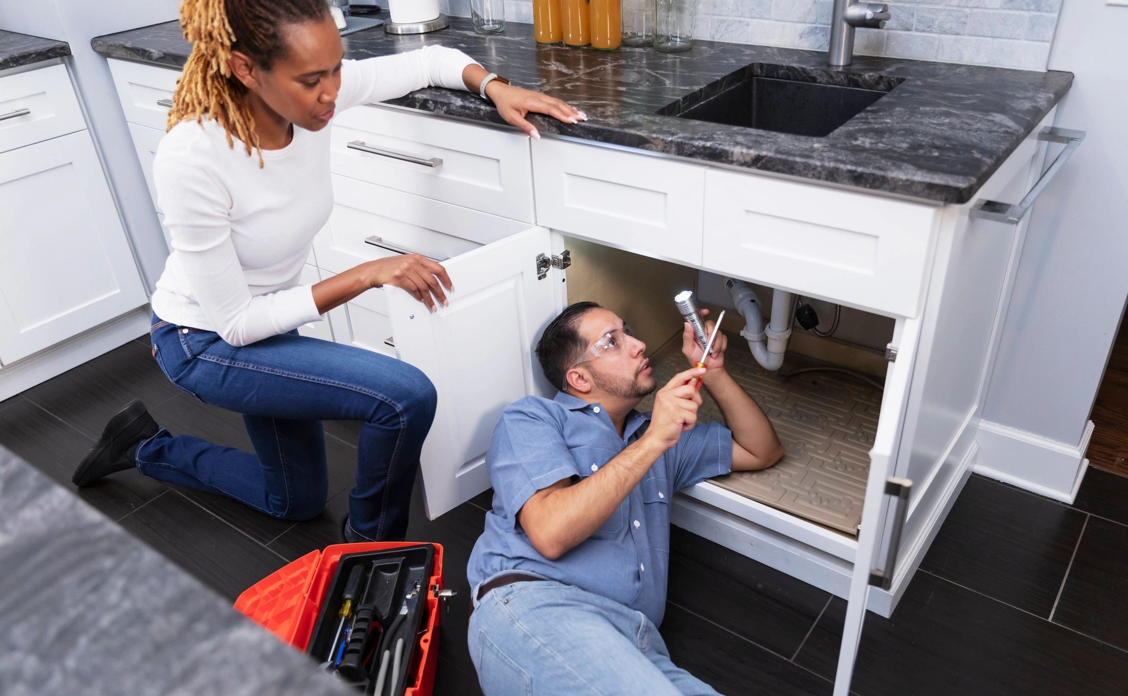 Plumber consulting with homeowner near a kitchen sink