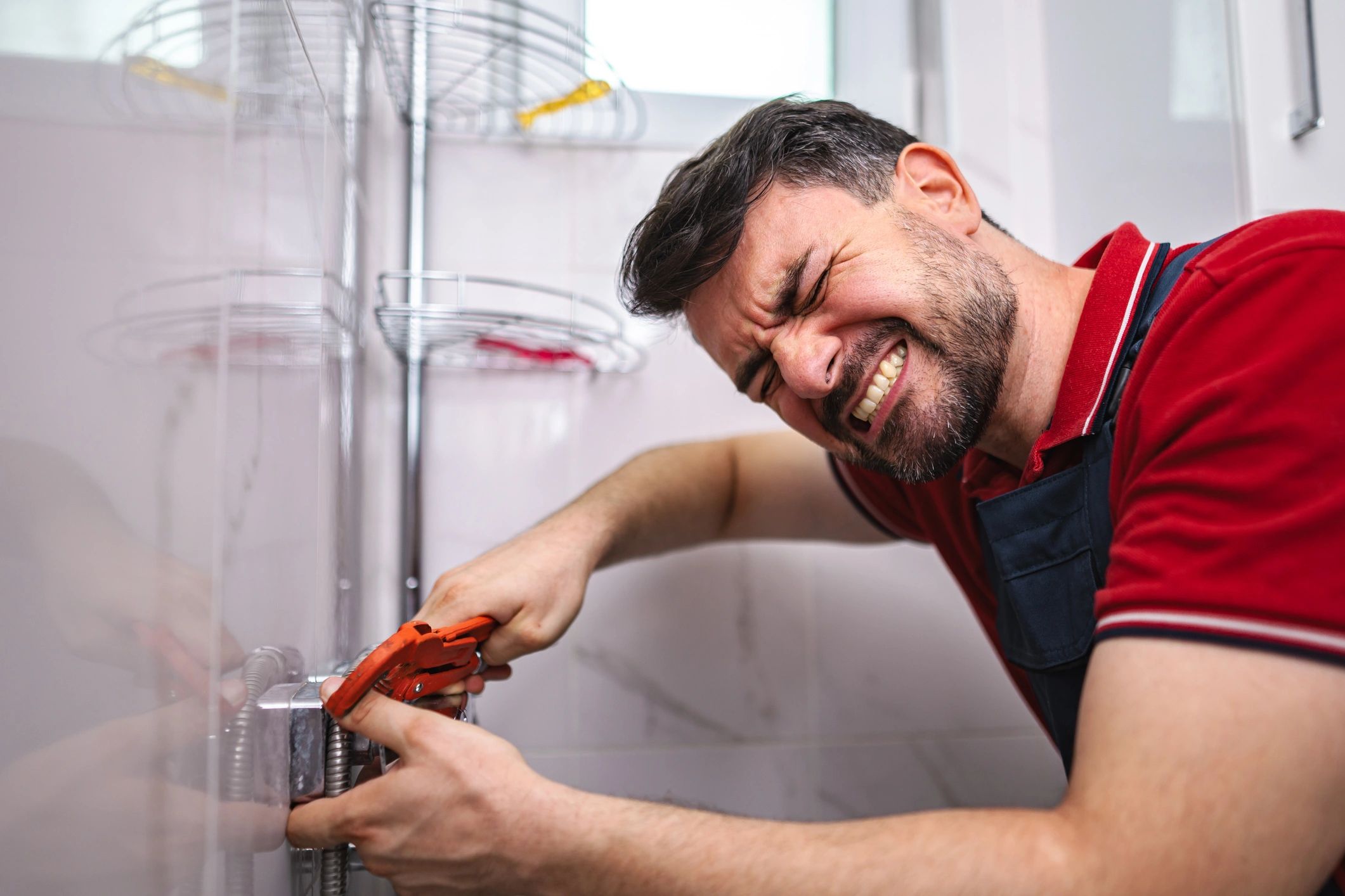 Plumber tightening a plumbing fitting with pliers