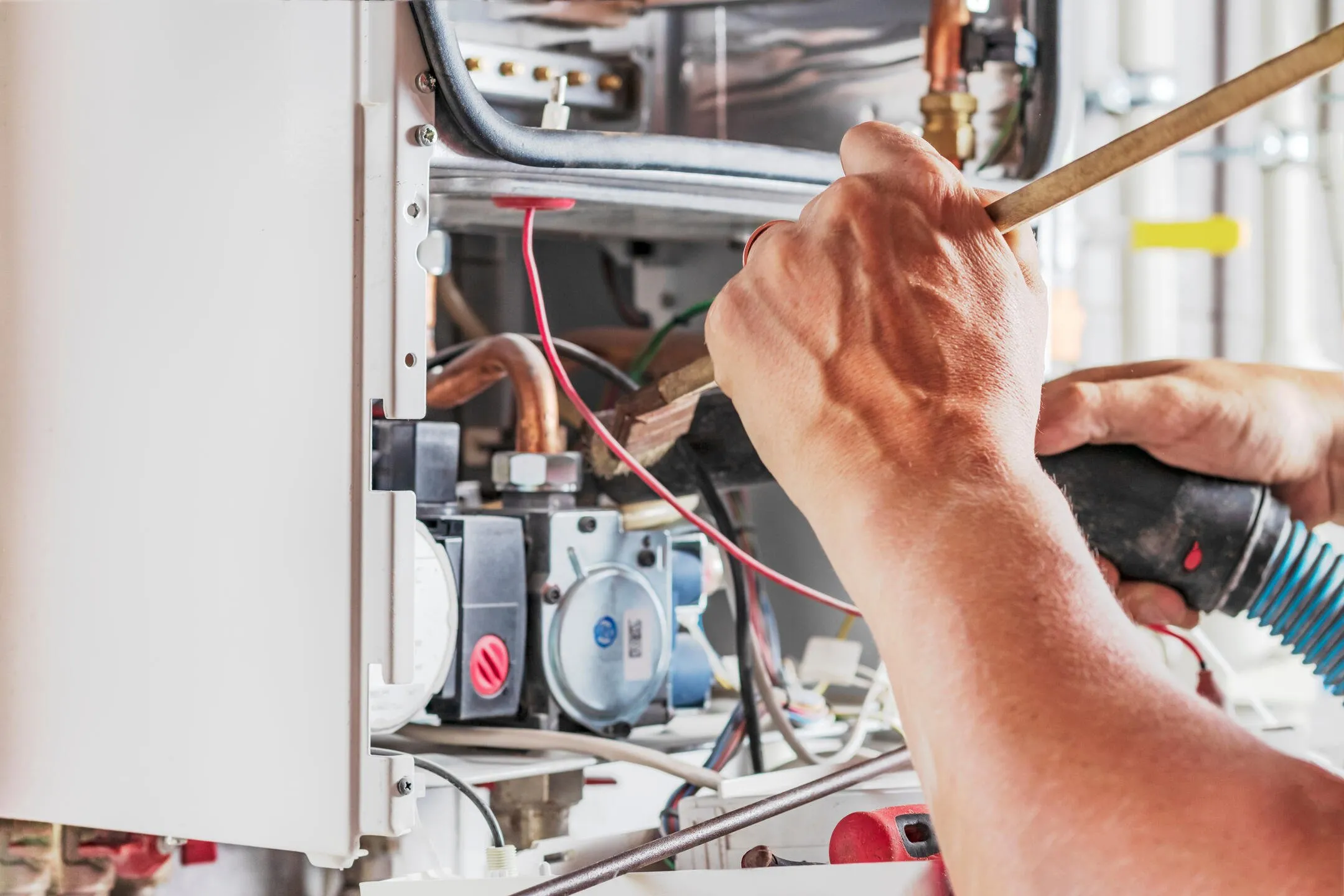 Technician cleaning a water heater unit